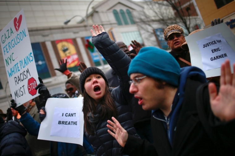 Protesters, demanding justice for Eric Garner, hold placards while shouting slogans in downtown White Plains, New York, December 5, 2014.