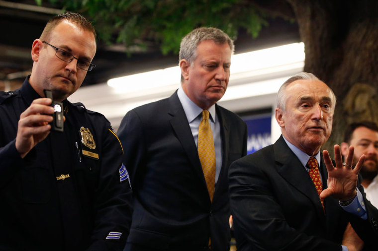 New York Police Department Commissioner Bill Bratton (R) speaks while NYPD Sergeant Joseph Freer holds a body camera and New York City Mayor Bill de Blasio looks on during a traffic stop demonstration of the pilot program involving 60 NYPD officers dubbed 'Big Brother' at the NYPD police academy in the Queens borough of New York, December 3, 2014.