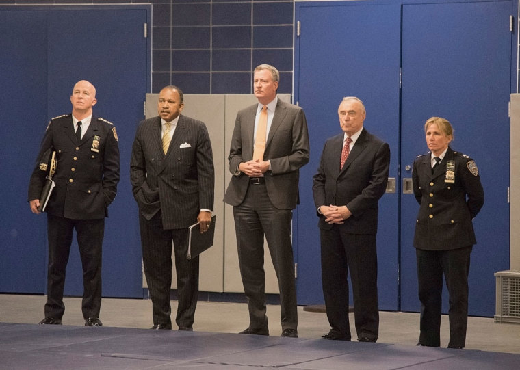New York City Mayor Bill de Blasio (C) and Police Commissioner Bill Bratton (2nd R) join other officials as they watch a demonstration at the new NYPD police Academy in the Queens borough of New York, December 4, 2014. De Blasio and Bratton held a news conference later and discussed newly implemented training procedures in the wake of the chokehold death of Eric Garner.