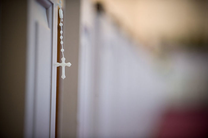Rosary beads hanging from a pew during a Catholic mass at Marine Corps Base Quantico, Virginia.
