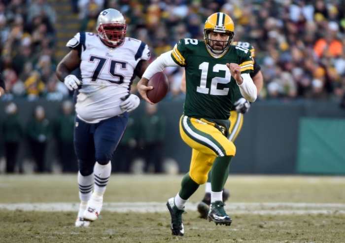 Green Bay Packers quarterback Aaron Rodgers (12) scrambles for a first down against the New England Patriots at Lambeau Field in this 2014 file photo.