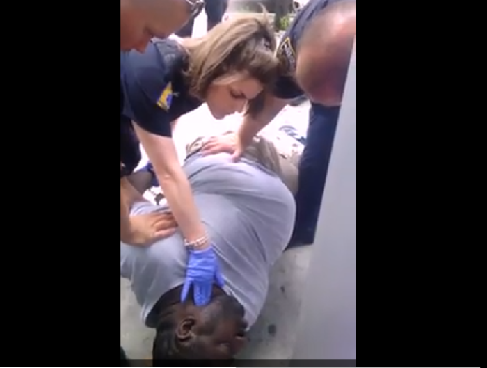 Eric Garner, 43, lays dying in a swarm of NYPD officers and an EMT representative last summer.