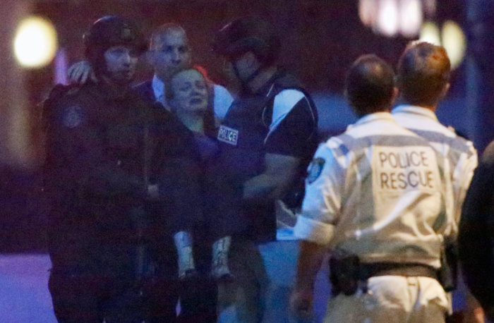 Police rescue personnel carry an injured woman from the Lindt cafe, where hostages are being held, at Martin Place in central Sydney December 16, 2014. Australian security forces on Tuesday stormed the Sydney cafe where several hostages were being held at gunpoint, in what looked like the dramatic denouement to a standoff that had dragged on for more than 16 hours.