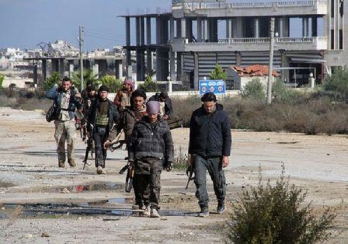 Rebel fighters walk around al-Hamidiyeh base, one of two military posts they took control of from forces loyal to Syria's President Bashar al-Assad in the northwestern province of Idlib December 15, 2014.