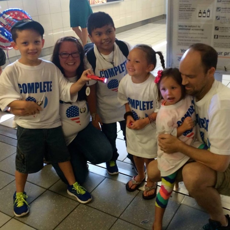 Hudson Kern, 9, (center) uniting with his adoptive family, Carrie, Jason and their other three children. August, 2014.