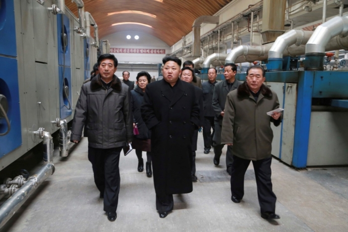 North Korean dictator Kim Jong Un (front C) gives field guidance at the Kim Jong Suk Pyongyang Textile Mill in this undated photo released by North Korea's Korean Central News Agency in Pyongyang, December 20, 2014.