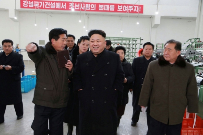 North Korean leader Kim Jong Un (front C) smiles as he gives field guidance at the Kim Jong Suk Pyongyang Textile Mill in this undated photo released by North Korea's Korean Central News Agency in Pyongyang, December 20, 2014.