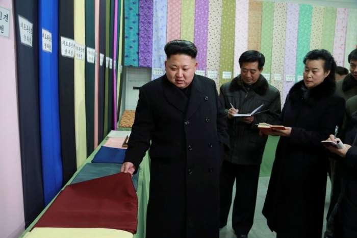 North Korean leader Kim Jong Un (L) gives field guidance at the Kim Jong Suk Pyongyang Textile Mill in this undated photo released by North Korea's Korean Central News Agency in Pyongyang, December 20, 2014.