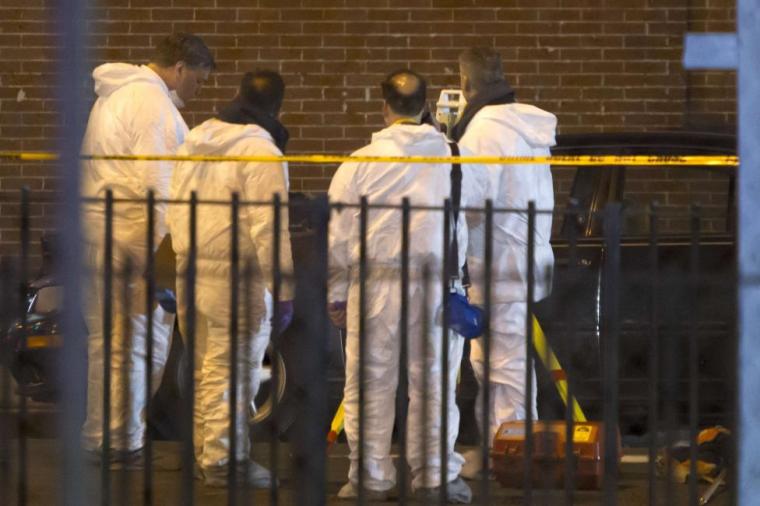 Forensic officers examine the scene of a shooting where two New York Police officers were shot dead in the Brooklyn borough of New York, December 20, 2014.