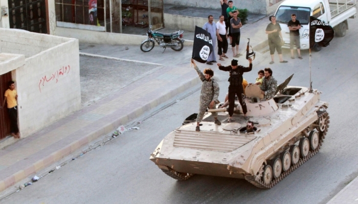 Militant Islamist fighters take part in a military parade along the streets of northern Raqqa province, June 30, 2014.