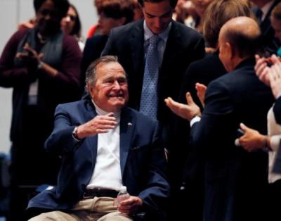 Former United States President George H. W. Bush is brought into the auditorium where his son Former United States President George W. Bush speaks about his new book titled ''41: A Portrait of My Father'' at the George Bush Presidential Library Center in College Station, Texas November 11, 2014.