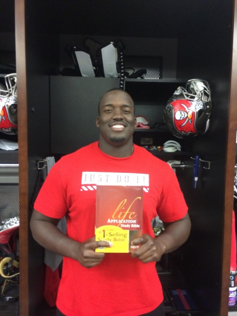 Kevin Pamphile participates in Athletes for Charity's Bible giveaway.