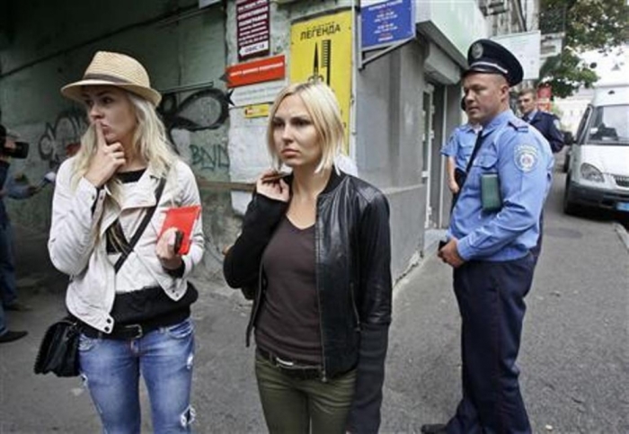 Activists of Ukrainian women's rights group Femen Yana Zhdanova (C) and Alexandra Shevchenko (L) stand near their office after a police search in Kiev, August 27, 2013.