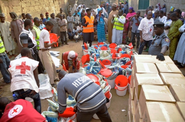Displaced people gather as the Red Cross in Kano distributes relief materials to displaced victims of the Boko Haram violence, at a relief camp in Dawaki, a local government area in Kano, December 16, 2014.