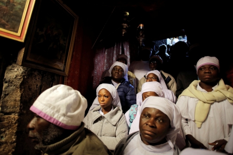 Nigerian pilgrims pray inside the Grotto, where Christians believe Virgin Mary gave birth to Jesus, during Christmas celebrations at the Church of the Nativity in the West Bank town of Bethlehem, December 24, 2014.