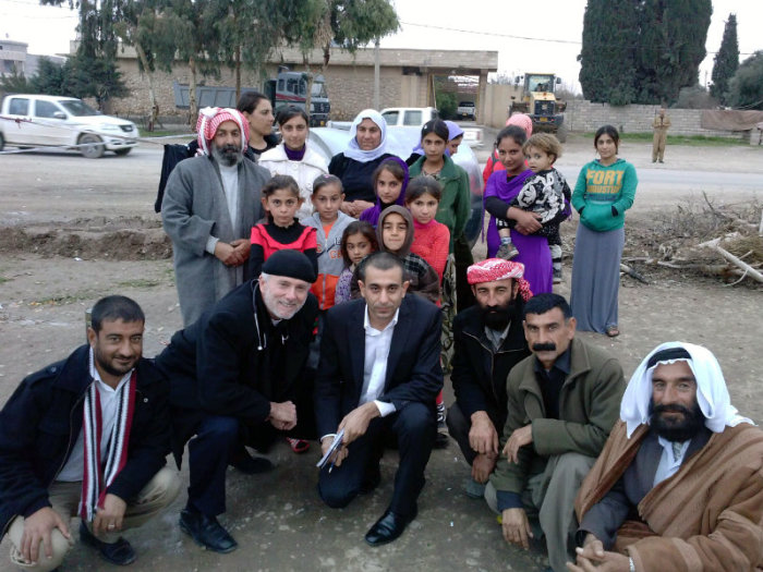 New York City pastor William Devlin, second from left in the front, squats next to Yazidi activist Murad Ismael, in Iraq in this undated photo.