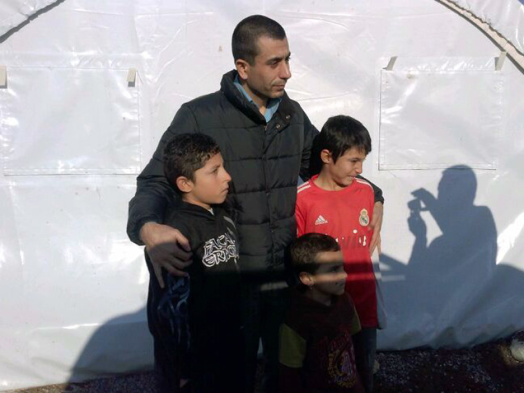 U.S.-based Yazidi activist Murad Ismael stands with three young boys at a refugee camp in Dohuk, Iraq, in this undated photo.