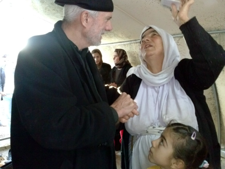 Pastor William Devlin listens to a Yazidi woman at a refuge camp in Dohuk, Iraq, in this undated photo.