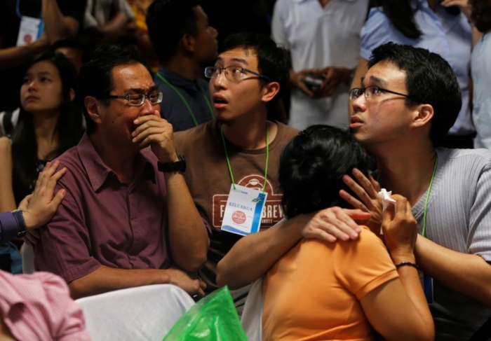 Family members of passengers onboard missing AirAsia flight QZ8501 cry at a waiting area in Juanda International Airport, Surabaya December 30, 2014. Indonesian rescuers saw bodies and luggage off the coast of Borneo island on Tuesday and officials said they were '95 percent sure' debris spotted in the sea was from a missing AirAsia plane with 162 people on board. Indonesia AirAsia's Flight QZ8501, an Airbus A320-200, lost contact with air traffic control early on Sunday during bad weather on a flight from the Indonesian city of Surabaya to Singapore.