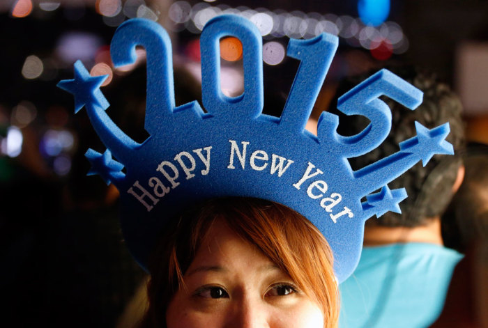 A woman wears a head band displaying 2015 as she waits for the annual New Year fireworks display on Sydney Harbour, Australia, December 31, 2014.