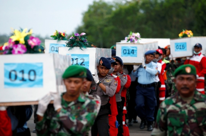 Caskets containing the remains of AirAsia QZ8501 passengers recovered from the sea are carried to a military transport plane before being transported to Surabaya, where the flight originated, at the airport in Pangkalan Bun, Central Kalimantan January 2, 2015. Ships and aircraft criss-crossed the seas off Borneo on Friday hunting for the wreck of the Indonesia AirAsia passenger jet, but bad weather was again hindering the search for the plane and the black box flight recorders that should reveal why it crashed.