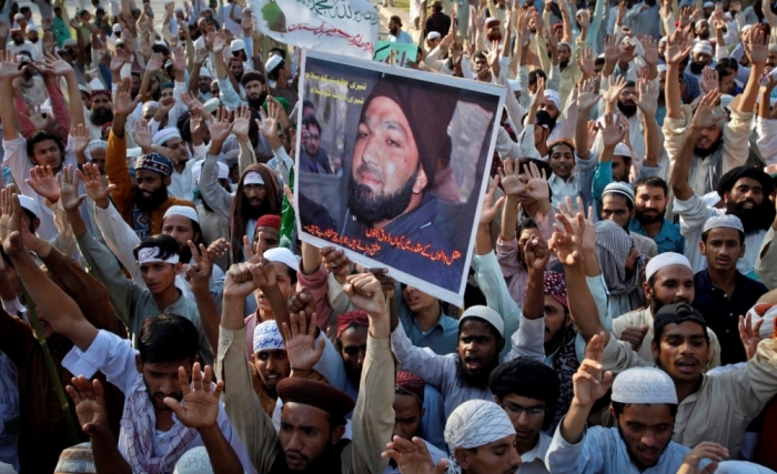 Some 300 supporters from various religious parties hold a poster of convicted killer Mumtaz Qadri while shouting slogans during a protest against the sentence of Qadri in Lahore, Pakistan, October 12, 2011. A Pakistani court on October 1,2011, sentenced to death the killer of Salman Taseer, the governor of Pakistan's largest province, after he had called for reform of a law against blasphemy, a defence lawyer and state-run media said.