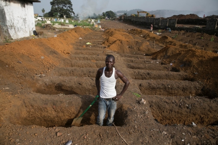 A grave digger prepares new graves at a cemetery in Freetown, Sierra Leone, December 21, 2014. 