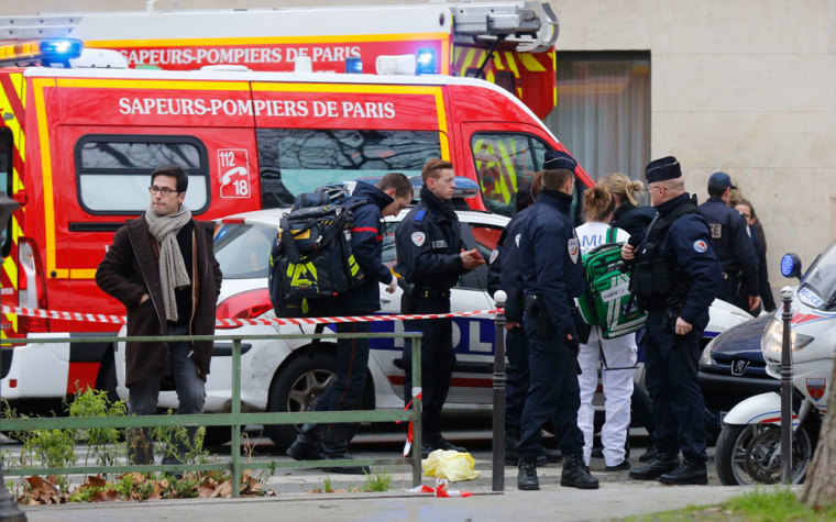 A view shows policemen and rescue members at the scene after a shooting at the Paris offices of Charlie Hebdo, a satirical newspaper, January 7, 2015. Eleven people were killed and 10 injured in shooting at the Paris offices of the satirical weekly Charlie Hebdo, already the target of a firebombing in 2011 after publishing cartoons deriding Prophet Mohammad on its cover, police spokesman said. Five of the injured were in a critical condition, said the spokesman. Separately, the government said it was raising France's national security level to the highest notch.