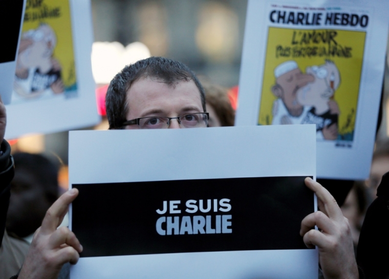 A man holds a placard which reads 'I am Charlie' to pay tribute during a gathering at the Place de la Republique in Paris, January 7, 2015, following a shooting by gunmen at the offices of weekly satirical magazine Charlie Hebdo. Gunmen stormed the Paris offices of the weekly satirical magazine Charlie Hebdo, renowned for lampooning radical Islam, killing at least 12 people, including two police officers in the worst militant attack on French soil in recent decades. The French president headed to the scene of the attack and the government said it was raising France's security level to the highest notch.