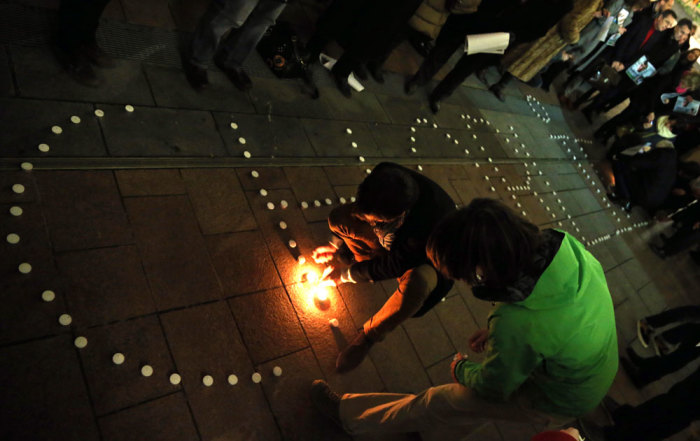 People try to light candles to form the word 'Charlie' to pay tribute to the victims of a shooting by gunmen at the offices of weekly satirical magazine Charlie Hebdo in Paris, in front of the European Parliament in Brussels January 7, 2015. Gunmen stormed the Paris offices of the weekly satirical magazine Charlie Hebdo, renowned for lampooning radical Islam, killing at least 12 people, including two police officers in the worst militant attack on French soil in recent decades