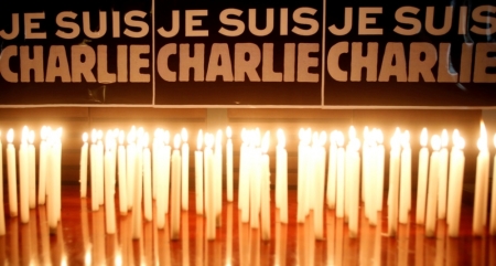 Candles are seen in front of a banner that reads "I am Charlie" during a minute of silence for victims of the shooting at the Paris offices of weekly newspaper Charlie Hebdo on Wednesday, at the French Embassy in Hanoi, Vietnam, January 8, 2015. France began a day of mourning for the journalists and police officers shot dead on Wednesday morning by black-hooded gunmen using Kalashnikov assault rifles.