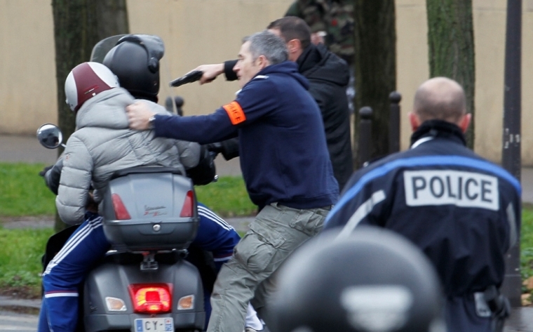 French police forcibly stop at gun point young people on a scooter as they arrive near the scene of a hostage taking at a kosher supermarket in eastern Paris January 9, 2015. Several people were taken hostage at a kosher supermarket in eastern Paris on Friday after a shootout involving a man armed with two guns, a police source said. There were unconfirmed local media reports that the man was the same as the one suspected of killing a policewoman in a southern suburb of Paris on Thursday. A police source had told Reuters earlier he was a member of the same jihadist group as the two suspects in Wednesday's attack at weekly newspaper Charlie Hebdo.