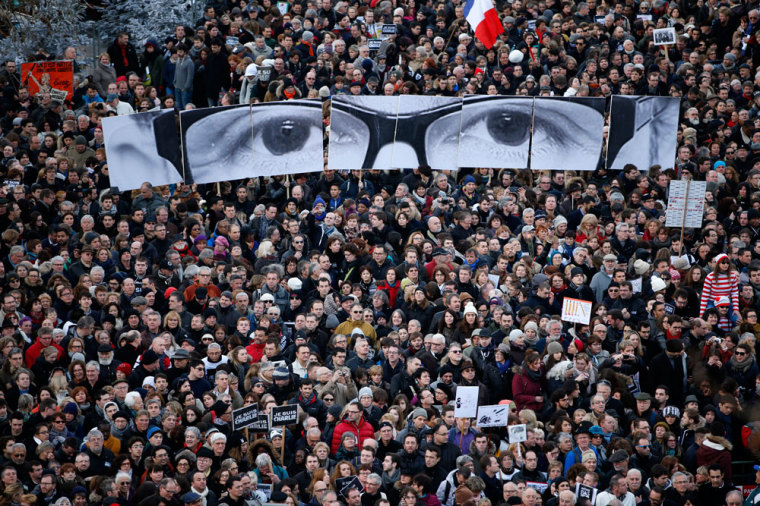 People hold panels to create the eyes of late Charlie Hebdo editor Stephane Charbonnier, known as 'Charb', as hundreds of thousands of French citizens take part in a solidarity march (Marche Republicaine) in the streets of Paris January 11, 2015. French citizens will be joined by dozens of foreign leaders, among them Arab and Muslim representatives, in a march on Sunday in an unprecedented tribute to this week's victims following the shootings by gunmen at the offices of the satirical weekly newspaper Charlie Hebdo, the killing of a police woman in Montrouge, and the hostage taking at a kosher supermarket at the Porte de Vincennes.