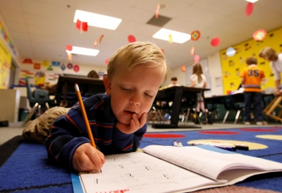 First grader Adam Kotzian does his writing work on the floor of his classroom at Eagleview Elementary school in Thornton, Colorado, March 31, 2010.
