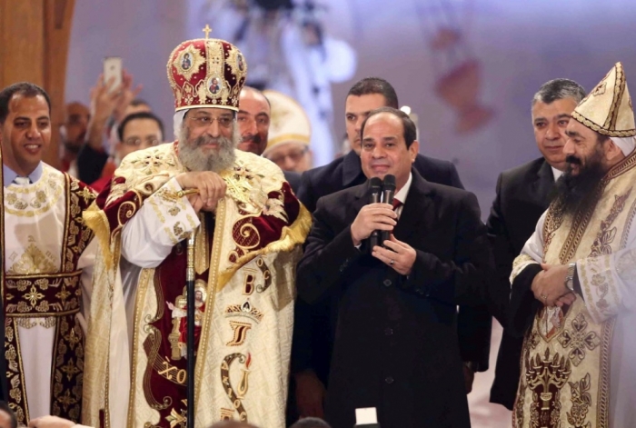 Egyptian President Abdel Fattah al-Sisi (2nd R) talks next to Coptic Pope Tawadros II as he attends Christmas Eve Mass at St. Mark's Cathedral, the seat of the Coptic Orthodox Pope in Cairo, January 6, 2015.