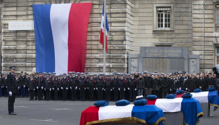 French police officers pay respects to the three officers killed during last week's attacks by Islamist militants, as they attend a national tribute at Paris Prefecture, January 13, 2015.
