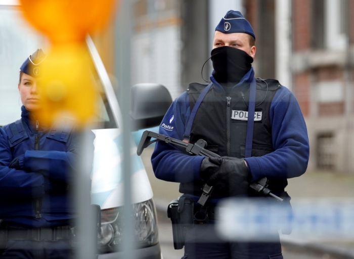 Belgian police stand guard outside an apartment in central Verviers, a town between Liege and the German border, in the east of Belgium, January 16, 2015. Belgian police were questioning 13 suspects on Friday detained during raids against an Islamist group they feared planned to attack police and two other people were held in France, state prosecutors said. A spokesman told a news conference there was still no apparent link to last week's Islamist attacks in Paris and the identities of two gunmen killed during one of the raids on Thursday, in the eastern town of Verviers, had yet to be confirmed.