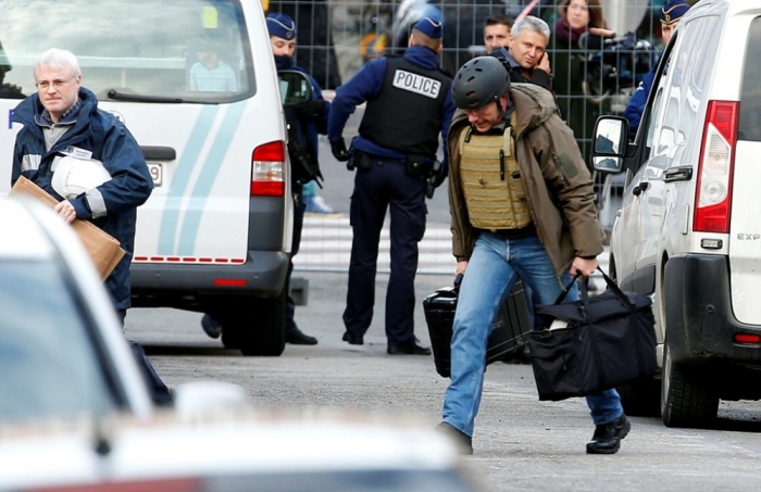 Belgian police investigators arrive outside an apartment in central Verviers, a town between Liege and the German border, in the east of Belgium, January 16, 2015.Belgian police were questioning 13 suspects on Friday detained during raids against an Islamist group they feared planned to attack police and two other people were held in France, state prosecutors said. A spokesman told a news conference there was still no apparent link to last week's Islamist attacks in Paris and the identities of two gunmen killed during one of the raids on Thursday, in the eastern town of Verviers, had yet to be confirmed.