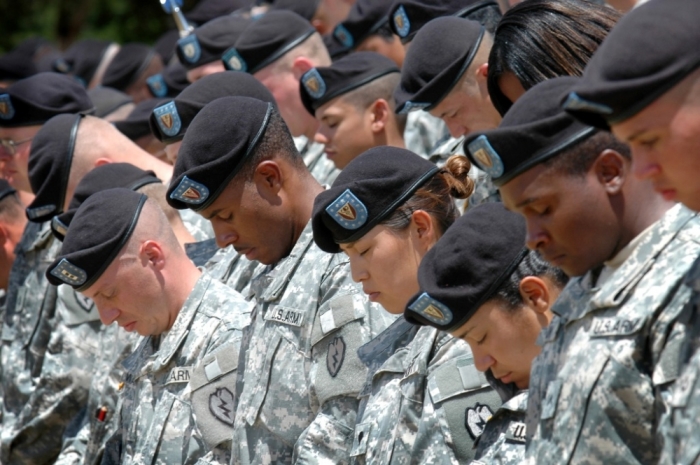Members of the 25th Infantry Division bow their heads in prayer during a deployment ceremony at Schofield Barracks, near Wahiawa, Hawaii, July 7, 2006. About 7,000 troops from Schofield will be leaving Hawaii in the next few weeks and will be deployed to Iraq. This continues the largest deployment of Hawaii-based troops since the Vietnam War.