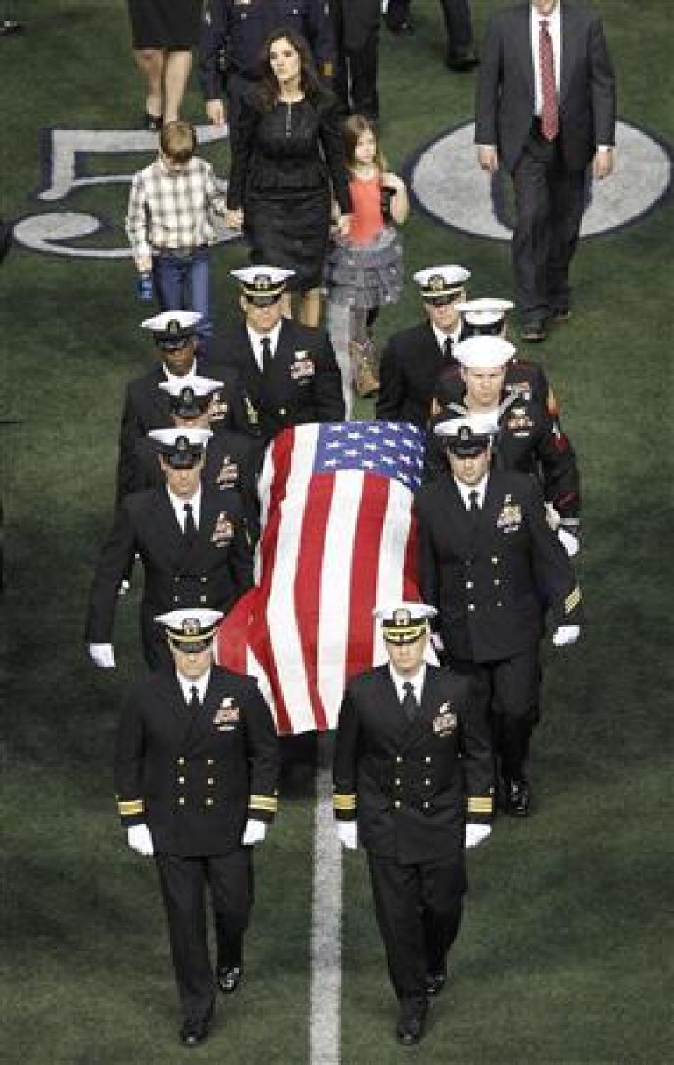 Taya Kyle (rear) and her children walk behind the coffin of her slain husband former Navy SEAL Chris Kyle during a memorial service for the former sniper at Cowboys Stadium in Arlington, Texas, February 11, 2013. Kyle was shot and killed with another man at a Texas gun range on February 2.