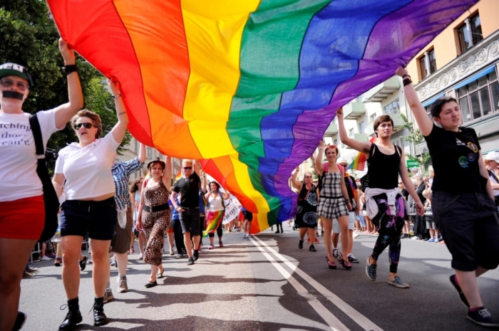 Participants carrying a rainbow flag attend the annual gay pride parade in Stockholm, Sweden, August 2, 2014.