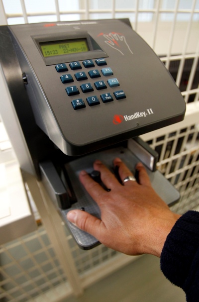 A man tests a hand biometrics recognition system at the entrance of the National Prison Service School in Agen, southwestern France, November 22, 2010.