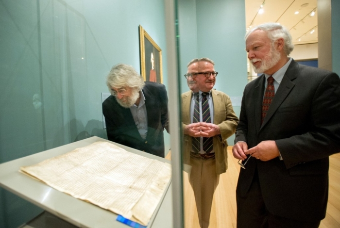 Visitors to the Museum of Fine Arts in Boston, including Peter Drummery (C), of the Massachusetts Historical Society, exhibit curator Gerald Ward (R) view one of four remaining copies of the original Magna Carta, a document written in 1215, June 30, 2014. An inspiration for the U.S. Constitution and Bill of Rights, the document is on loan from England's Lincoln Cathedral.