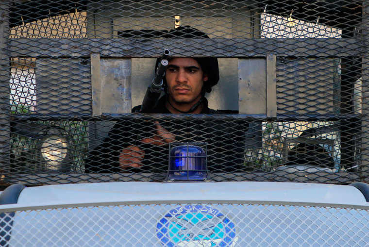 A policeman stands guard behind an armoured vehicle at Talaat Harb Square in Cairo, January 28, 2015.