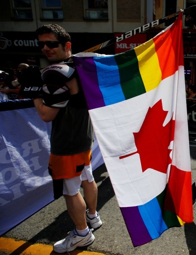 A man holds a rainbow colored Canadian flag attached to a hockey stick during the 'WorldPride' gay pride Parade in Toronto, June 29, 2014.
