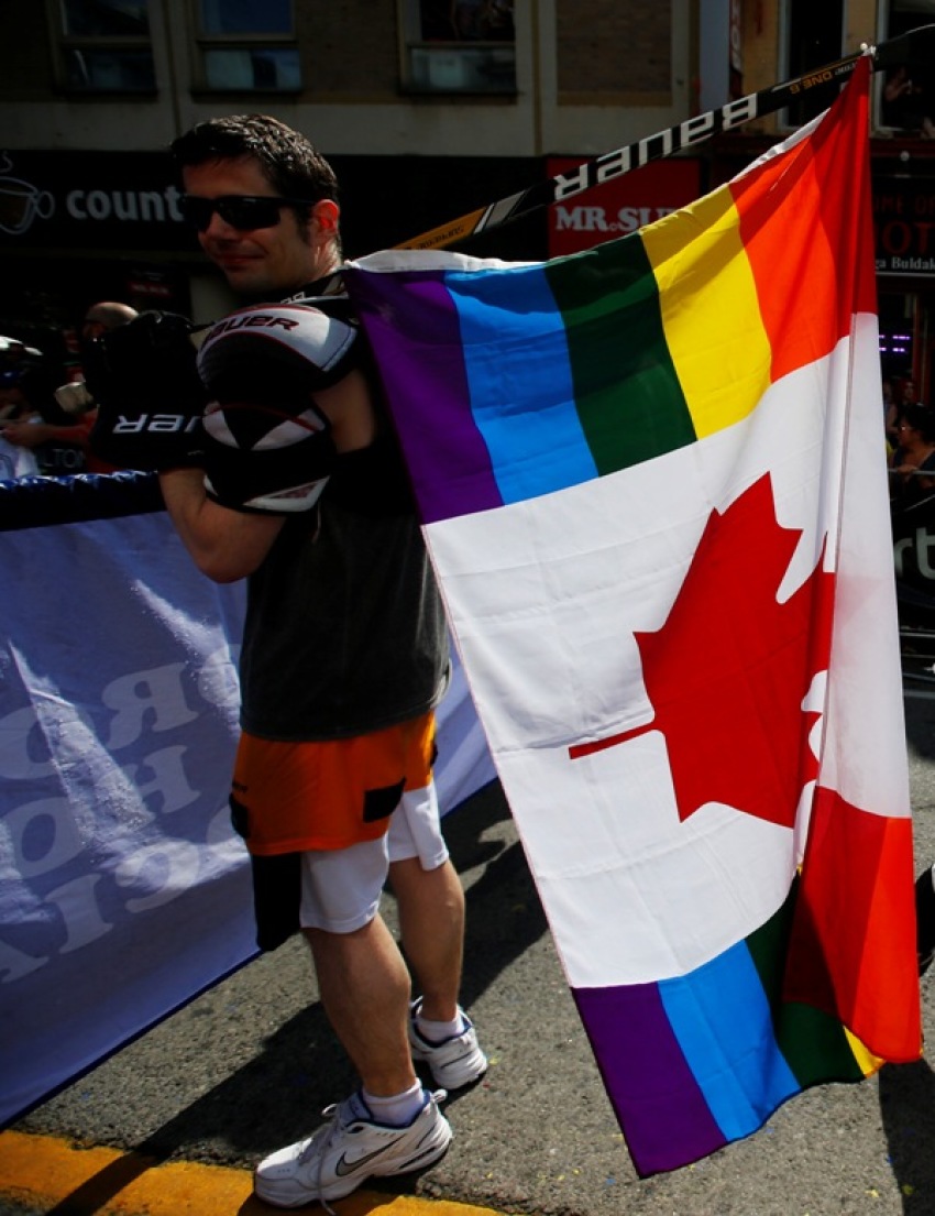 A man holds a rainbow colored Canadian flag attached to a hockey stick during the "WorldPride" gay pride Parade in Toronto, June 29, 2014.