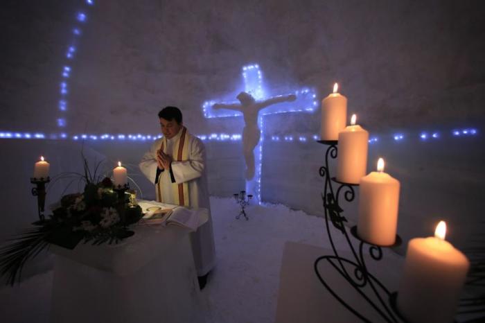Franciscan monk Iulian Misariu prays during the inaugural mass for a church made entirely from ice at Balea Lac resort in the Fagaras mountains, Romania, January 29, 2015.