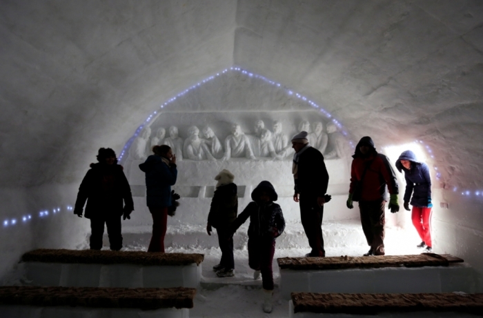 Tourists walk in front of an ice sculpture depicting the Last Supper as they visit a church made entirely from ice at Balea Lac resort in the Fagaras mountains, Romania, January 28, 2015. Picture taken January 28, 2015.
