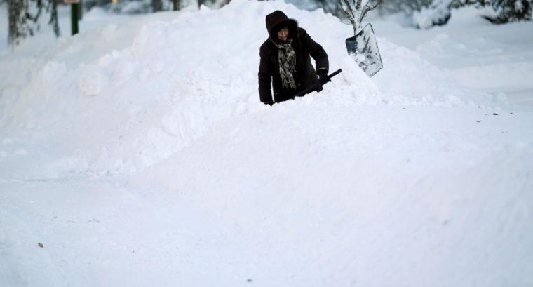 A woman shovels snow out a driveway in the Chicago suburb of Wilmette, Illinois, February 2, 2015. A huge winter storm hit the northeastern United States on Monday, the region's second snowy blast in less than a week, after leaving more than a foot of snow in the Chicago area. The area was hit with blizzard conditions yesterday and the temperature dropped to well below freezing.