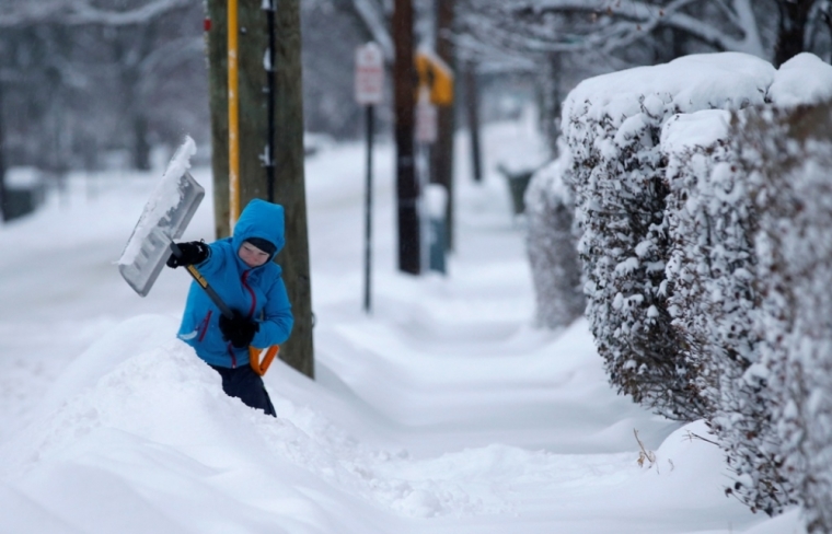 A young boy shovels snow along Broadway in the New York City suburb of Nyack, New York, February 2, 2015. The northeastern United States braced for the second major snow storm in a week on Monday after a huge winter system dumped more than a foot of snow in the Chicago area, closing schools from the Midwest to New England.